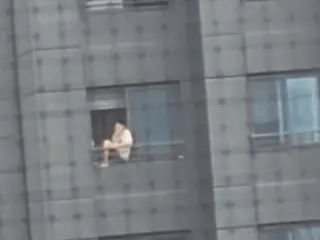 韩国一名男子坐在20层公寓楼栏杆上抽烟引发争议