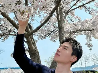 演员李东旭帅气的外貌在盛开的樱花下绽放